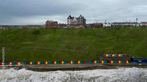 4k drone footage of the colourful beach huts along the sea front in Whitby, North Yorkshire, UK