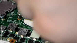 girl clicks the lock where the laptop processor chip is inserted. Computer repair technician. Work in the service center. Close up view