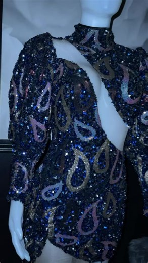 Giana Too Bring bold retro glamour straight into the now with Giana. This eye-catching mini dress is made to sparkle, sculpt, and turn heads from every angle. Perfect for nights out, birthdays, or anytime you want all eyes on you. Details:- Multi-colored sequined mini dress with a luxe, high-shine finish- Long sleeves with puffy, enhanced upper arms for dramatic flair- Mock / small collar for a polished, fashion-forward touch- Sheer mesh lace panels at the cleavage and legs to reveal skin in all