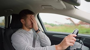 Tired man falling asleep while driving car on highway road. Sleepy male driver closes his eyes and lose concentration. Dangerous driving