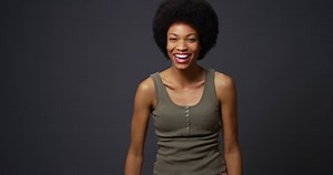 Adorable Black woman laughing and smiling at camera