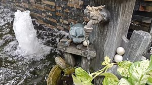 Slow motion video of water flowing from a faucet in a fountain