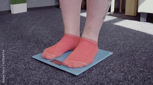 Young girl standing in front of electronic scales. Going to check weight. Loosing weight concept.