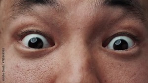 Portrait of Asian Man Face with Wide Surprised Eyes Looking at Camera Close Up. Astonishing Vision of Young Chinese Person with Ethnic Features. Modern Concept of One Student Gazing Scared and Shocked