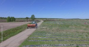 Tractor plowing fields, preparing land for sowing. Aerial view. Farmer in tractor preparing land in farmlands. Tractor plows a field. Agriculture industry, cultivation of land