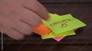 colored stickers with order numbers on the wooden surface. people take orders and tear off sheets of paper