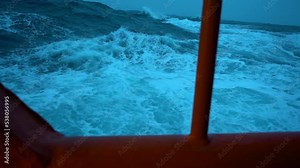 Storm. Side view from ship low over water. Slow motion high waves and splashes. White foam on wind. Wind breaks waves.