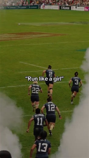 This woman was out on the rugby field when she showed the world exactly what “run like a girl” really looks like...You see these badass players in the dark blue uniforms sprinting full speed out of the smoke on the field, numbers 2, 3, 22, 12 flying past, then it cuts to player #2 bursting out of the Paris 2024 entrance with the American flag behind her, hair flying as she hauls ass with that rugby ball tucked tight.Close-ups show her face locked in, teeth gritted, powering through while another