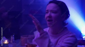 The girls are sitting at the table at the party, smoking vape. They dance to rap, hip-hop.