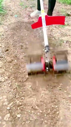 Using a motorized hand tiller to quickly prepare a garden bed for seeds