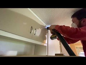 Flush cutting drywall against cabinets using DeWalt oscillating tool and homemade blade.