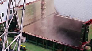 Wheat loading to bulker ship cargo container at sea grain terminal in seaport. Grain shipment from silos to bulk vessel via trunk at sea port. Transportation of agricultural harvest commodities.