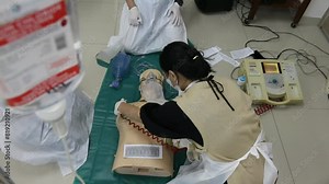 Doctor intensivist performs defibrillation to critical patient. Emergency and first aid class on cpr doll, Cardiac life support Stock Video