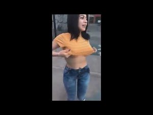 Video of a woman with large breasts undressing in the street