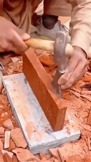 Using traditional masonry tools for scoring and cleanly breaking a solid red clay brick