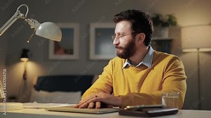 Man is scared, terrified, aghast emotion. Frightened bearded man with glasses in home office working at computer and sees something terrible on laptop screen and screams in fright Stock Video