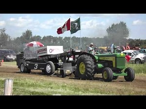 John Deere 830 tractor pulling at an antique tractor pull competition.