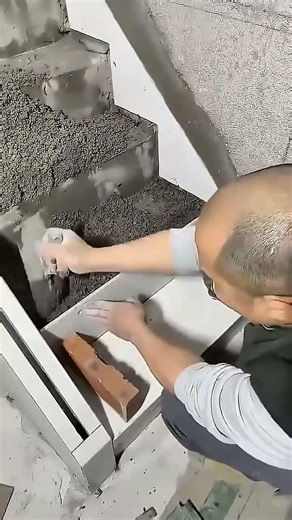 worker uses a laser level for precision while building concrete stairs