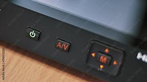 Turning power on and off on monitor with illuminated buttons.
