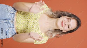 Vertical video of Young woman clapping excitedly to camera.