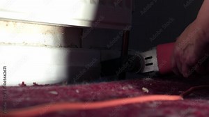 Using a power multi tool to saw house baseboards