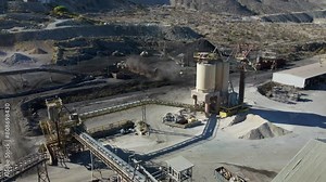 Aerial establishing overview of quarry fill with piles of sediment and sorting machines at a cement factory