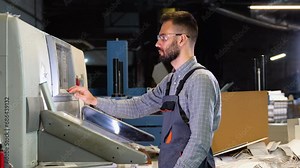 Technician operator checking input and output status on touchscreen front display monitor station at print plant factory