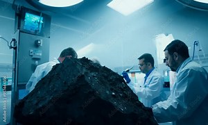 Scientists examining a meteorite in a lab