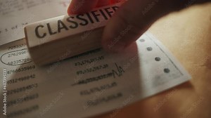 Retro looking document is stamped as classified for top security clearance level. Red ink rubber stamp - hand marks sensitive paper with bank account look and vintage dot matrix numbers and sums