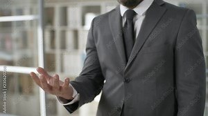 Footage suitable for adding AR graphics. Mid-section shot of businessman opening palm to turn on augmented reality screen while using nano device in office