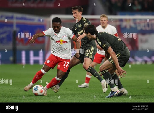 24 April 2026, Saxony, Leipzig: Soccer, Men: Bundesliga, RB Leipzig - 1. FC Union Berlin, Matchday 31, Red Bull Arena, Ridle Baku (RB Leipzig), Janik Haberer (1. FC Union Berlin) and Diogo Leite (1. FC Union Berlin) (l-r) fight for the ball. IMPORTANT NOTE: In accordance with the regulations of the DFL German Football League and the DFB German Football Association, it is prohibited to use or have used photographs taken in the stadium and/or of the match in the form of sequential images and/or vi