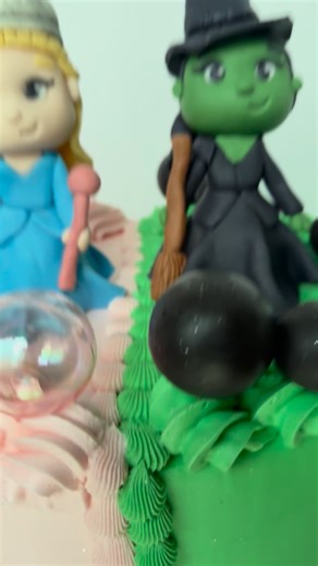 A very happy wicked birthday to celebrate Kolby! She got a wicked themed cake, highlighting both Elphaba and Glinda. They are sitting on top of a 9 inch three layer chocolate cake with Dubai chocolate and strawberry filling, chocolate buttercream crumb coat and vanilla buttercream main coat to achieve decor. . . . #cake #dubaichocolate #cakedecorating #cakedesign #wicked #wickedcake #halfandhalf #cakeart #glinda #elphaba | Neverland Creations LLC