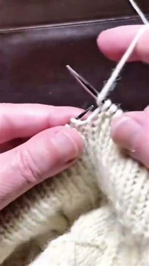 knitting wool stitches with needles by looping yarn steadily to form a fabric pattern slowly even