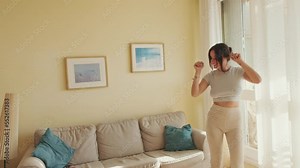 Young beautiful woman dancing at home, celebrating weekend, having fun. forward movement