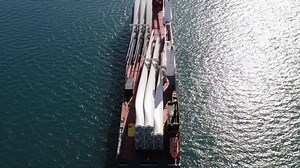 Heavy load carrier ship loaded with Electric Turbine Blades anchored at Sea, Aerial view.