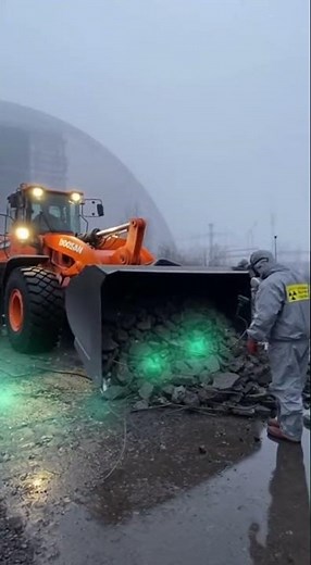 Doosan DL580 7 loader pushing radioactive debris at Chernobyl new safe confinement site, green radia