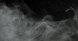 Organic cloud of dust particles floating on black screen overlay. Filmed with RED camera in slow motion.