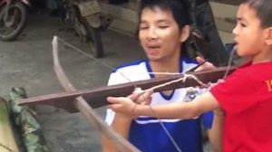 Kid casually pulls his tooth out using a crossbow