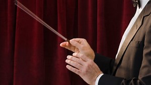 Why do conductors always conduct ahead of the beat?