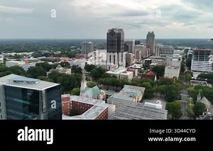 Aerial footage of Raleigh downtown skyline under a partly cloudy sunset sky.