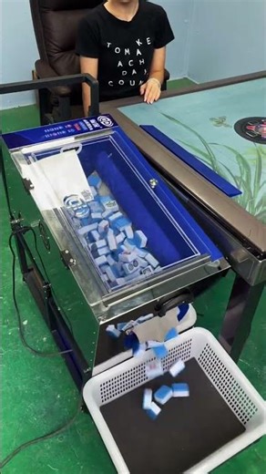 automatic mahjong table in operation, which collects, shuffles, and deals tiles electronically.