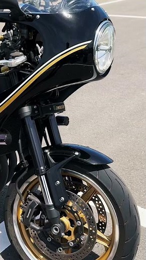 The Z900RS, with its full fairing and aggressive clip-on handlebars, evokes the classic café race...