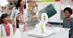 Science, teacher and chemistry experiment in classroom with excited children learning about chemical, explosion or reaction. Kids, applause and foam surprise from beaker in school, class or education