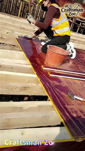 Female workers install composite wooden formwork on the floor of the construction site