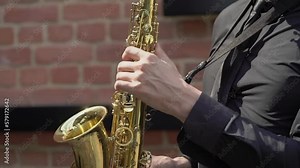 Saxophonist plays music. Musician blowing saxophone. Wind musical instruments - sax. Artist performs on outdoor stage, summer open air concert, jazz festival