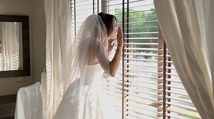 Smiling bride near window. Woman in dress waving hand. Like a princess in castle. I'm over here, darling.
