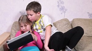 clip-8791474-brother-sister-playing-game-on-pad-sitting