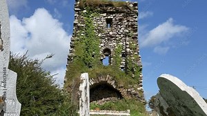 Castle and headstones ancient ruined castle in Waterford Ireland on a summer day