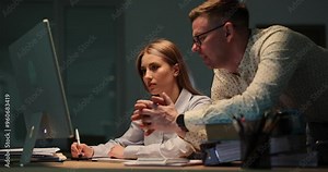 Male coworker explains task to female employee at workplace. Team gesture reflecting collaborative effort to ensure precision in results at senidarness