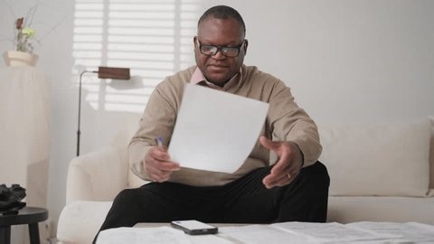 clip-4006413947-middle-aged-black-householder-checking-utility-bills ...